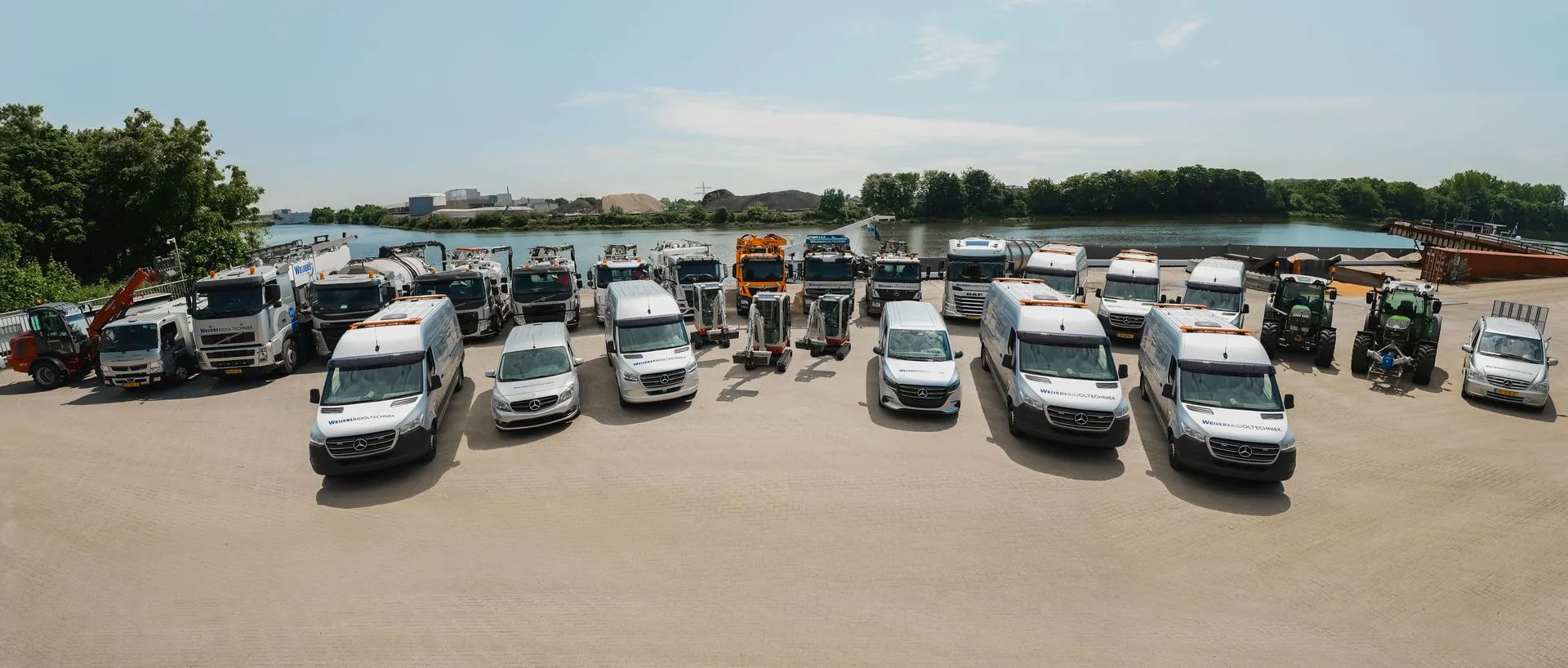 Het complete wagenpark van Weijers Riooltechniek opgesteld aan de Waal